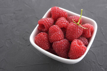Pattern of raspberry on dark rock background. Flat lay summer berries - red raspberries. Top view