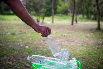 Woman hand picking up garbage plastic and Glass bottles for cleaning at park