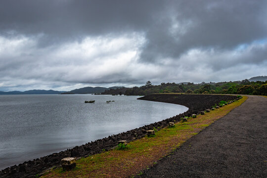 river serene back water with remote tarmac road and dramatic cloudy sky