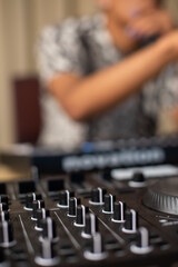 Blurred background of producer with focus on mixing board