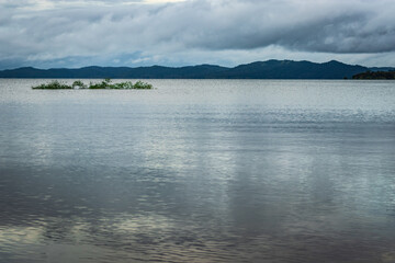river serene back water with mountain shadow and dramatic cloudy sky