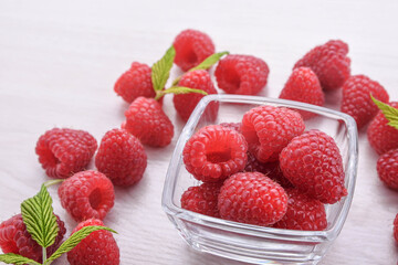Raspberries in a bowl on a wooden textured background
