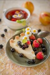 summer breakfast. a summer garden still life with a mug of tea, wildflowers and berries. garden aesthetics. cheesecake with berries	