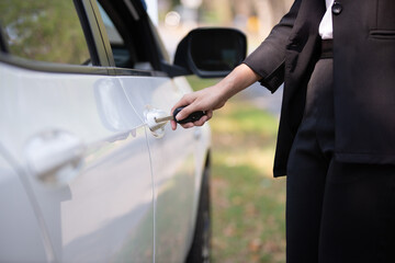 Asian woman sitting in a private car shows the keys in her hand.Selected focus