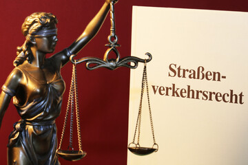 Symbolbild: Fachbuch Verkehrsrecht und eine Justitia