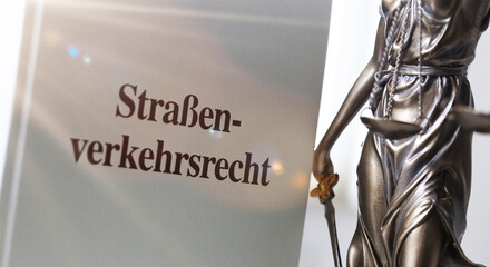 Symbolbild: Fachbuch Verkehrsrecht und eine Justitia