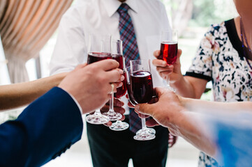 Cheers! People celebrate and raise glasses of wine for toast. Group of man and woman cheering with champagne.