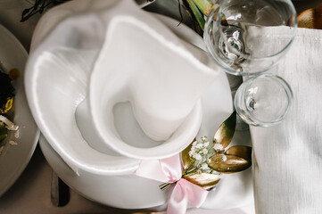Serving, setting table. Plate with silverware cutlery, linen napkin are decorated with gold branch...