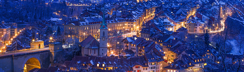 Banner of the old twon of Bern in winter blue hour with snowy and illuminated buildings,...