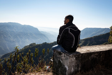 man watching the pristine nature at mountain range covered with white mist
