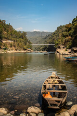 fisherman fishing traditional wood isolated at river edge with pebbles