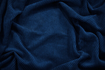 Beautiful dark blue fabric background. Wavy soft folds. Elegant navy blue background with copy space for design.