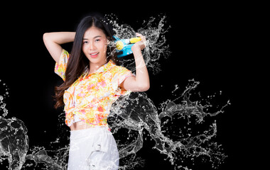 Portrait cheerful young asian woman holding plastic water gun Smiling and having fun playing in the water Songkran festival, Thailand. isolated on black background. Thai New Year's Day.