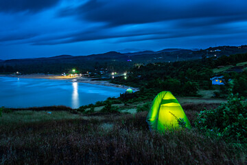 camping solo at mountain top with amazing view and dramatic sky at evening