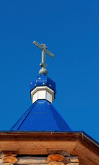 The upper part of the dome of the village Orthodox chapel. Blue dome against a blue sky. A symbol...