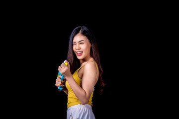 Portrait cheerful young asian woman holding plastic water gun Smiling and having fun playing in the water Songkran festival, Thailand. isolated on black background. Thai New Year's Day.