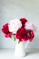 Vase with bouquet of beautiful peonies on table in room, close-up. Bloom. Peony. Postcard. 