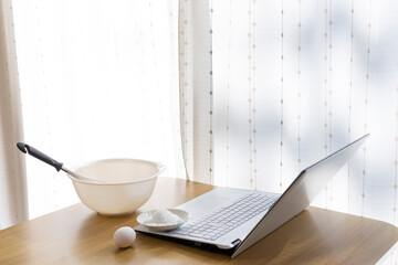 ノートパソコンを見てクッキーを作るイメージ