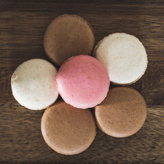 Chocolate, strawberry and vanilla macaroons arranged in a flower shape with petals from above