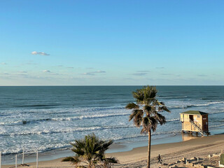  Sea waves in a sunny sunset, empty beach, lonely surfer