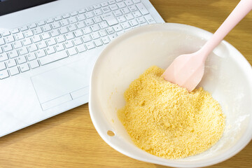 ノートパソコンを見てクッキーを作るイメージ
