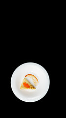 White plate with thin pancake with red caviar, over black background with copy space