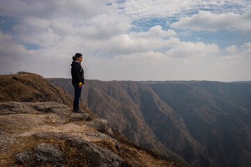 Fototapeta premium girl watching the beautiful mountain range from edge of mountain