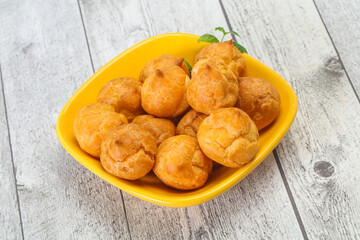 Sweet tasty profiteroles heap in the bowl