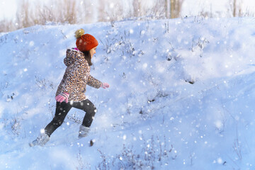 child girl runs and having fun in the winter forest, bright sunlight and shadows on the snow, beautiful nature