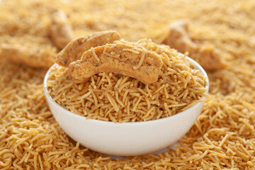 Indian spicy snacks (Namkeen) - Bikaneri Besan Bhujia in a white bowl, made with chickpea flour (Besan), side view.