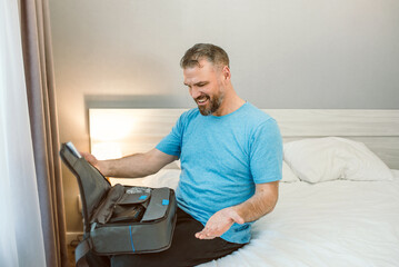 Mature happy man with chronic breathing issues considers using sitting on the bed in bedroom with...
