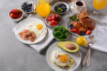 Healthy breakfast. Toast with avocado and egg, bacon and eggs, fresh and dried fruits, fresh juice