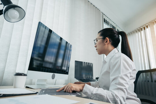Woman asian software developers are analyzing together about the code written into the program on the computer in office room.