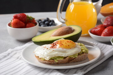 Healthy breakfast. Toast with avocado and egg, bacon and eggs, fresh and dried fruits, fresh juice