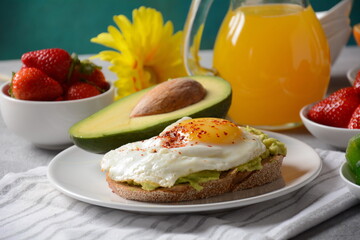 Healthy breakfast. Toast with avocado and egg, bacon and eggs, fresh and dried fruits, fresh juice