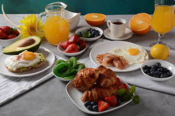 Healthy breakfast. Toast with avocado and egg, bacon and eggs, fresh and dried fruits, fresh juice