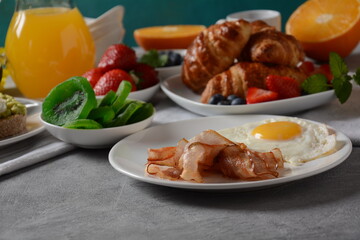 Healthy breakfast. Toast with avocado and egg, bacon and eggs, fresh and dried fruits, fresh juice