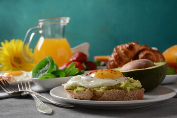 Healthy breakfast. Toast with avocado and egg, bacon and eggs, fresh and dried fruits, fresh juice