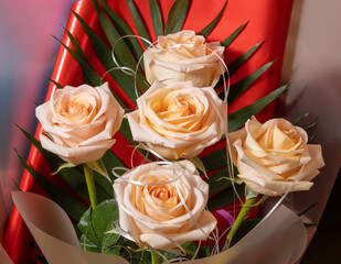 Peach-colored roses are collected in a beautiful gift bouquet