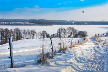 beautiful winter landscape, snow on the field and lake, Balloon in the sky, Masuria in Poland