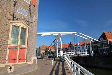 Historic houses in Enkhuizen, West Friesland, Netherlands, with the Drommedaris Gate Tower  (dated from 1540) on the left and a drawbridge