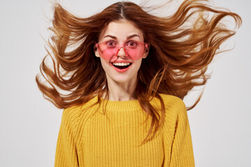 Fototapeta premium cheerful woman wearing pink glasses yellow sweater evacuation hair close-up