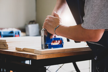 Entrepreneur  Woodwork holding a Tacker to assemble the wood pieces as the customer ordered