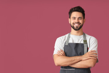 Young man wearing apron on color background - Powered by Adobe