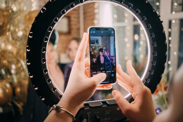 People taking photos on smartphone and ring light on a party