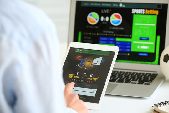 Woman Placing Sports Bet With Tablet Computer And Laptop, Closeup