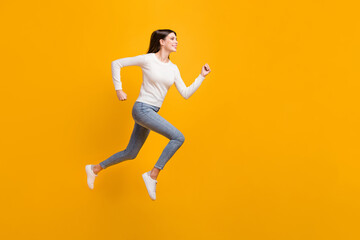 Full size profile photo of hooray nice girl jump run wear sweater jeans sneakers isolated on yellow color background