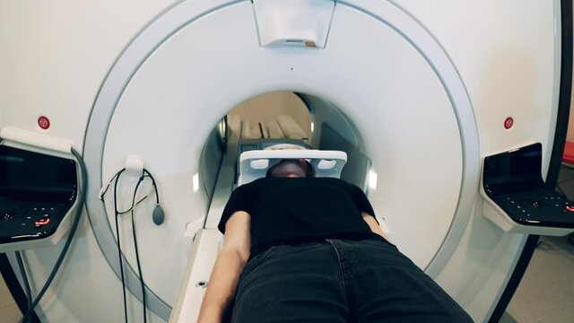CT scanner with a male patient getting moved into it