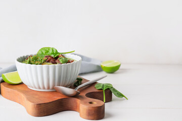 Bowl with tasty spinach soup on light background