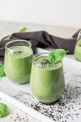 Glasses of healthy spinach smoothie on light table